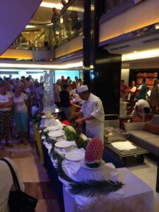 a group of people in a room with a buffet table full of food