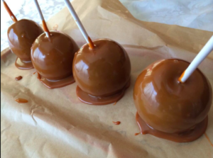 a group of caramel apples on a brown paper