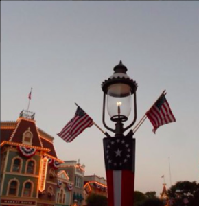 a street lamp with flags in front of buildings