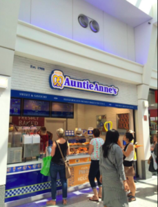 a group of people walking in front of a bakery