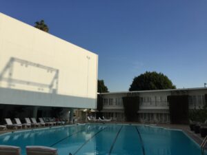 a swimming pool with chairs and a building