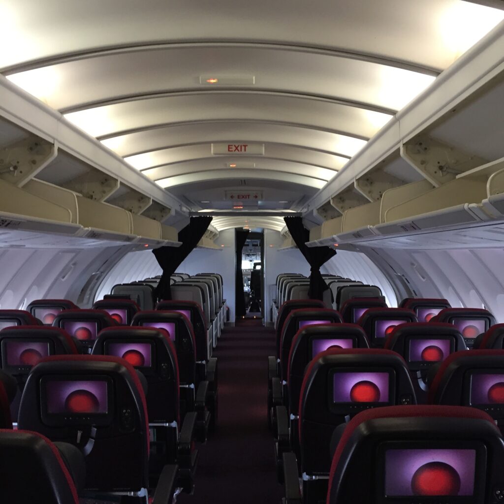 the inside of an airplane with red seats