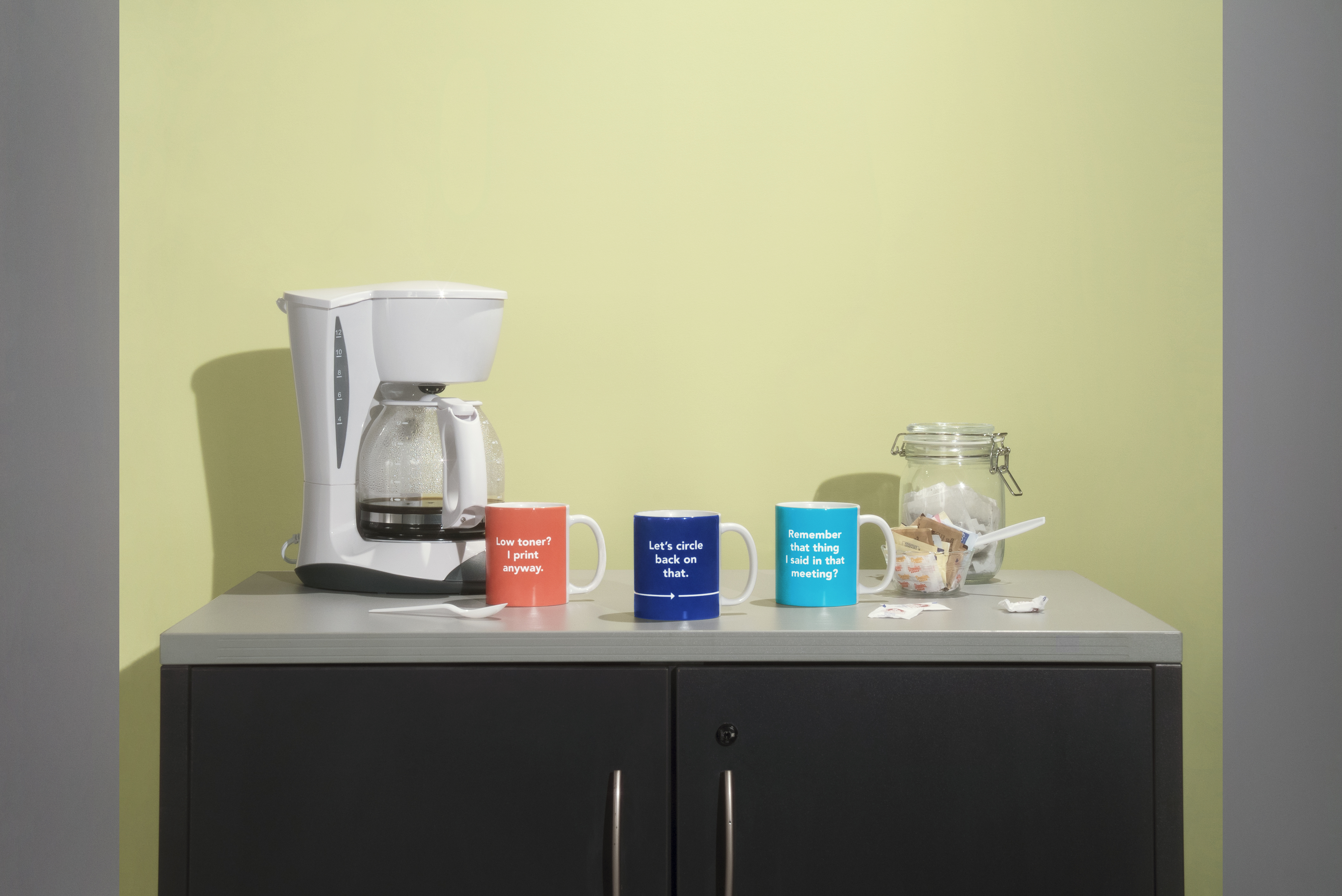 a coffee maker and mugs on a counter