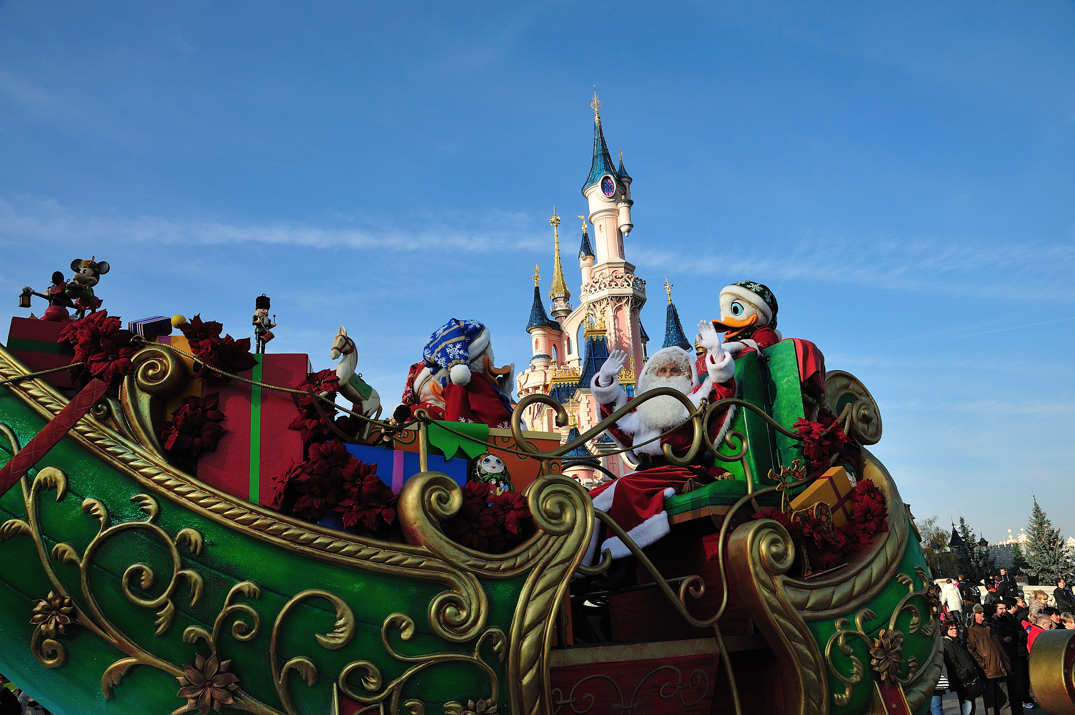 a large colorful sleigh with santa claus and a castle in the background