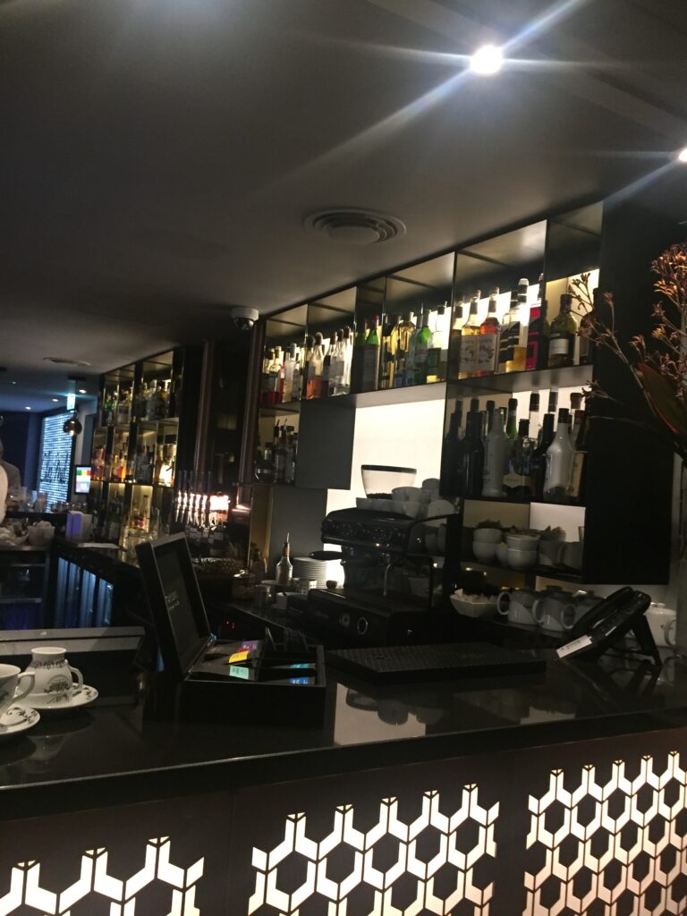 a bar with shelves of liquor and cups