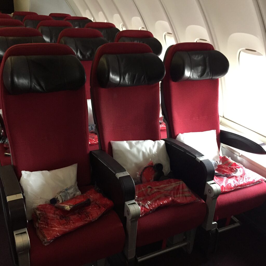 a row of red and black seats on an airplane
