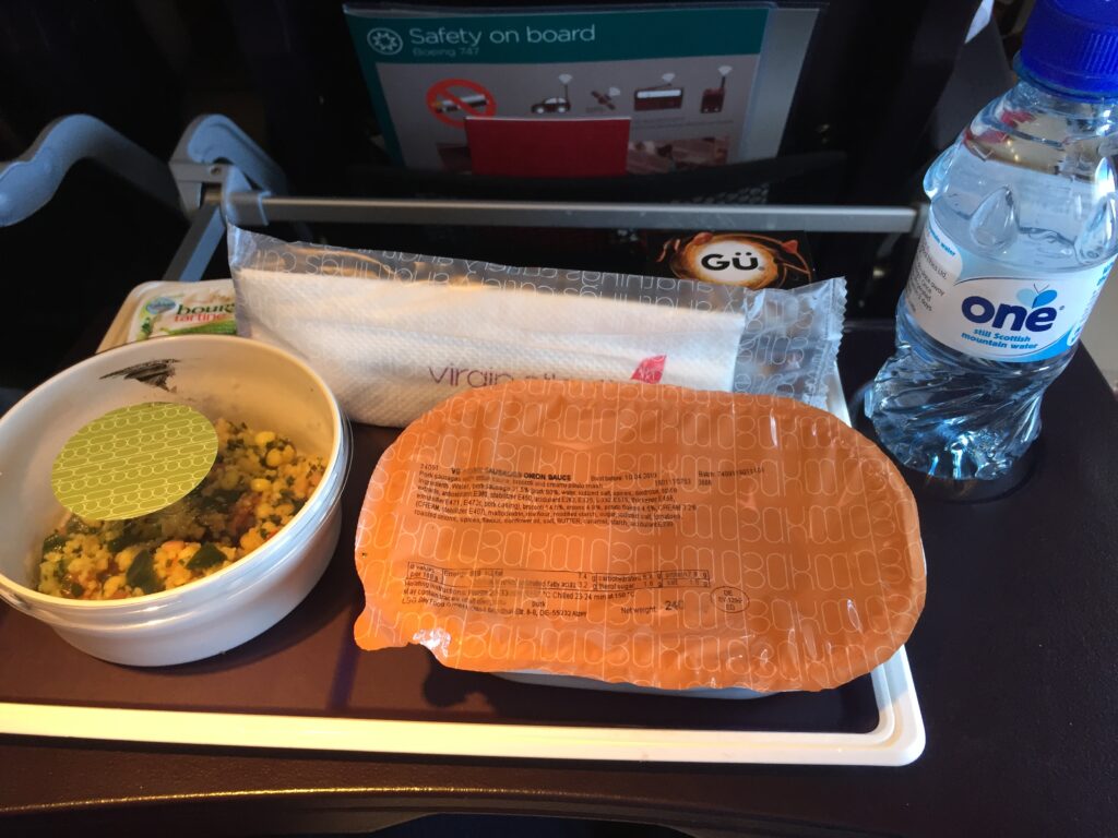 food on a tray with a bottle of water and a plastic bag