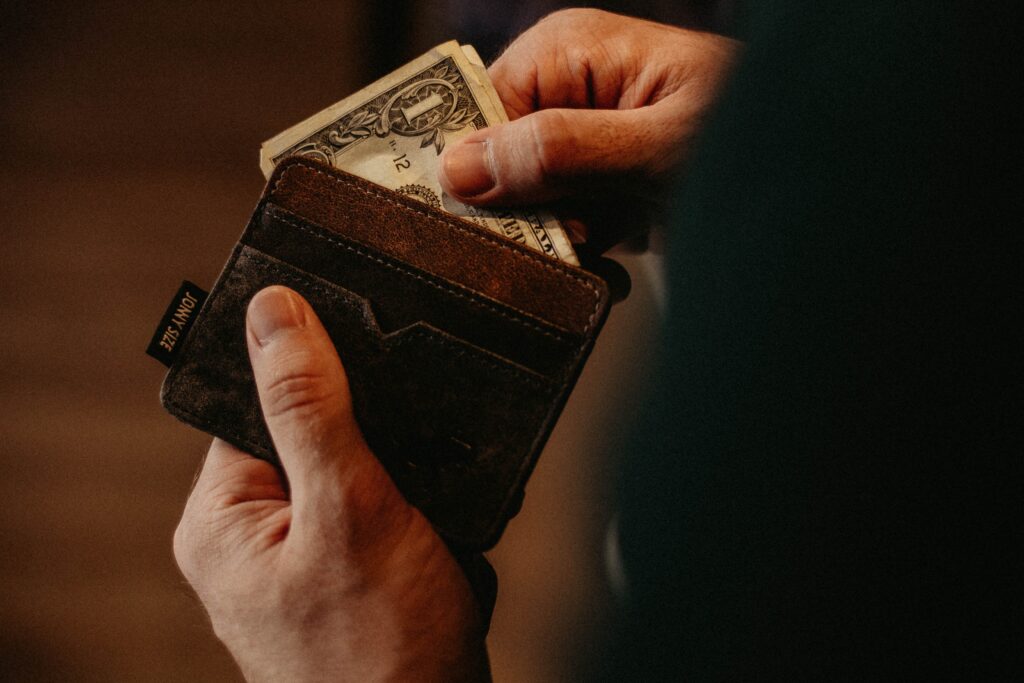 a person holding a wallet with money